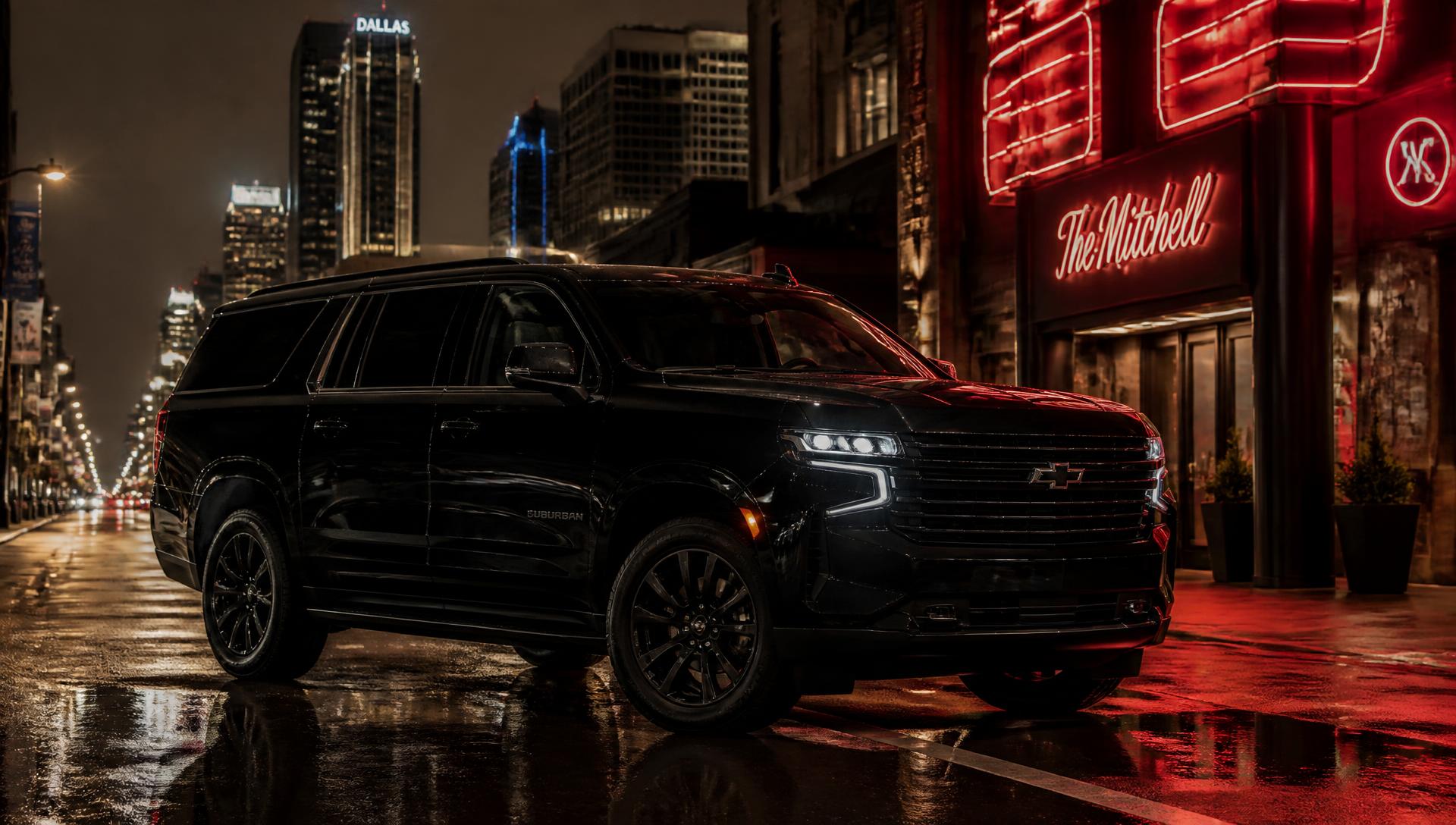 Black luxury SUV on a wet city street at night